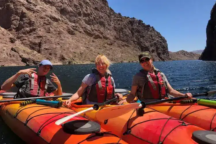 Small group in kayaks posing for a picture on a river.