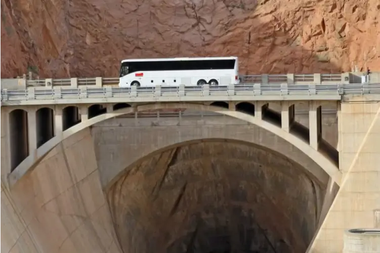 Tour bus driving on top of the Hoover Dam.