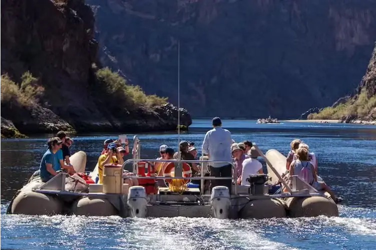 Tour group on a moving boat viewing the surrounding river.